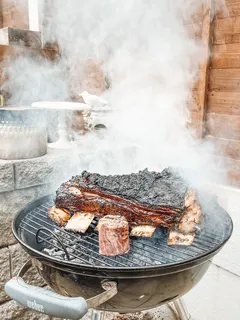 Grilled meat served on black round plate, juicy and charred