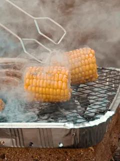 Fresh corn cobs on a clear glass tray