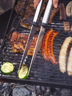 Grilled Franconian bratwurst, beef fillet, and zucchini on barbecue