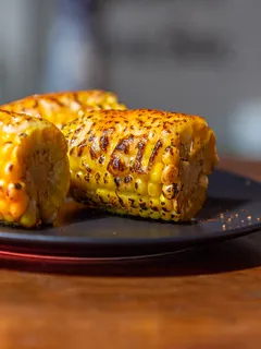 Grilled corn on the cob with char marks, served and ready to eat