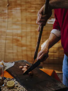 Person slicing Uruguayan chorizo sausage with knife